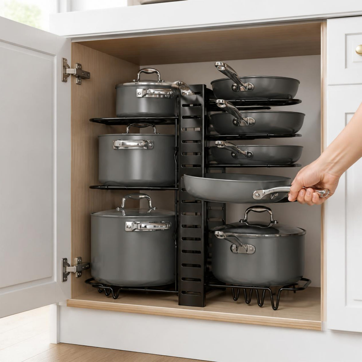 Pulling a pan from the pot rack inside a kitchen cabinet