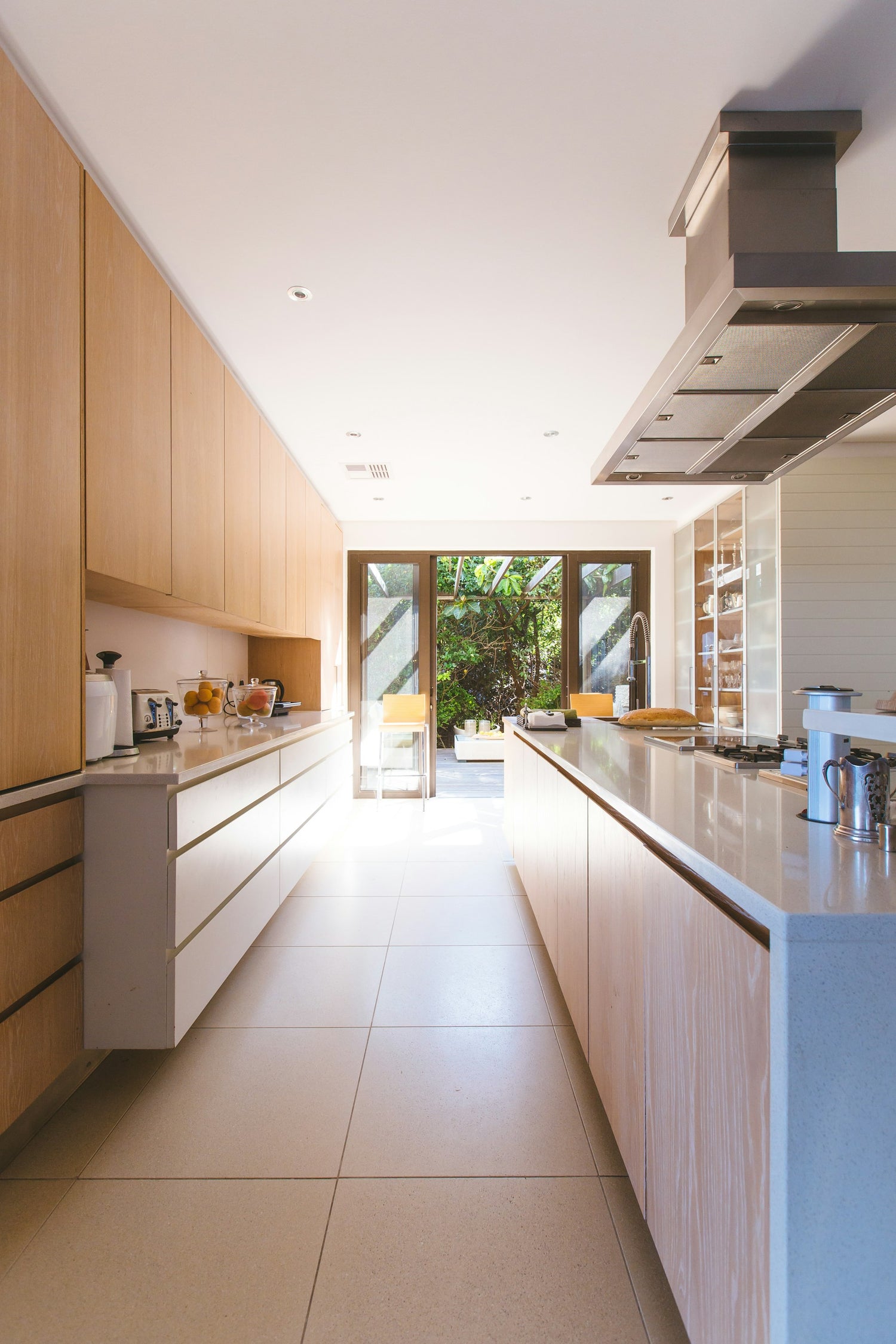 A bright, tidy galley kitchen with warm wood and white cabinets