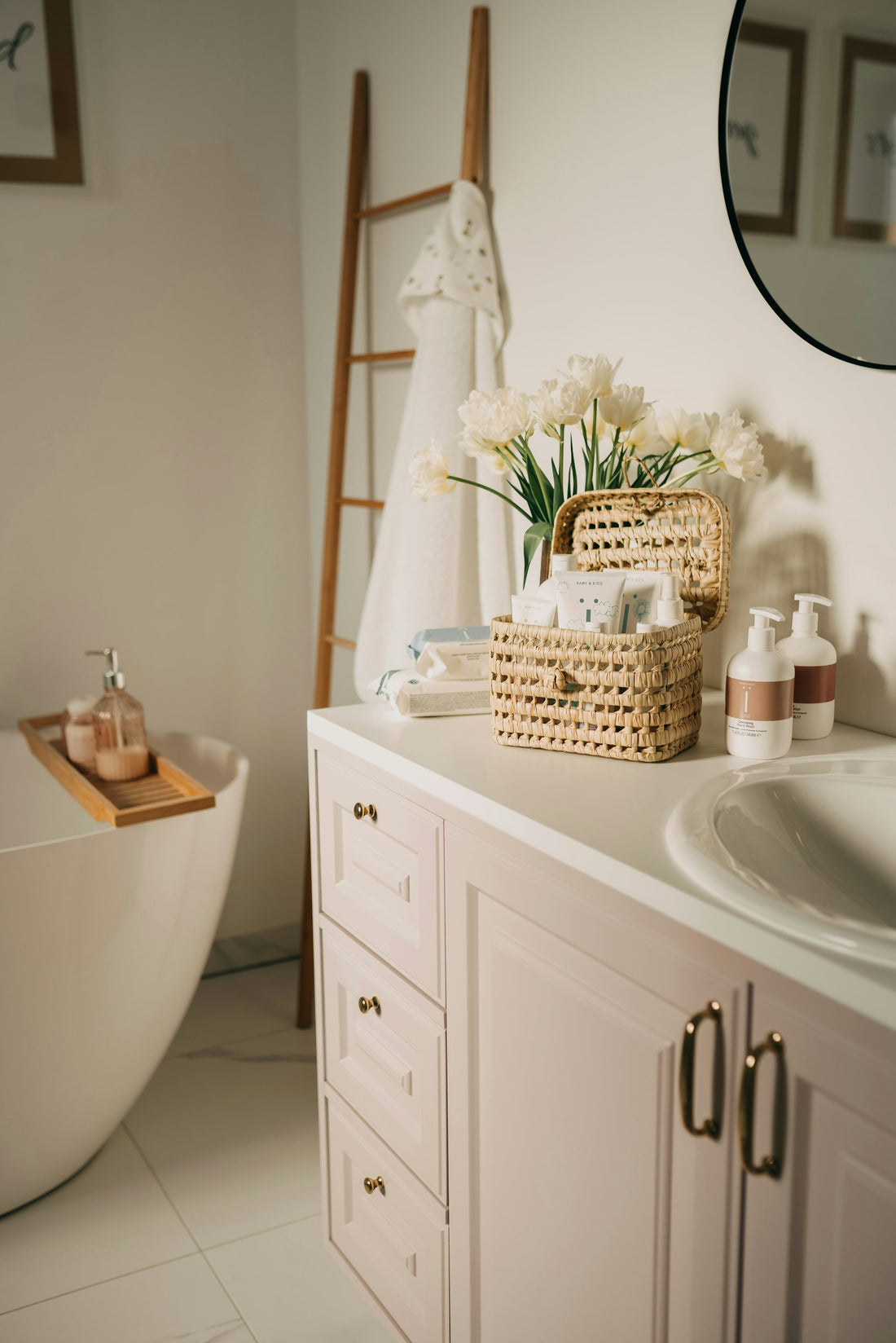 A calm, organised bathroom vanity with a woven basket, toiletries and fresh flowers